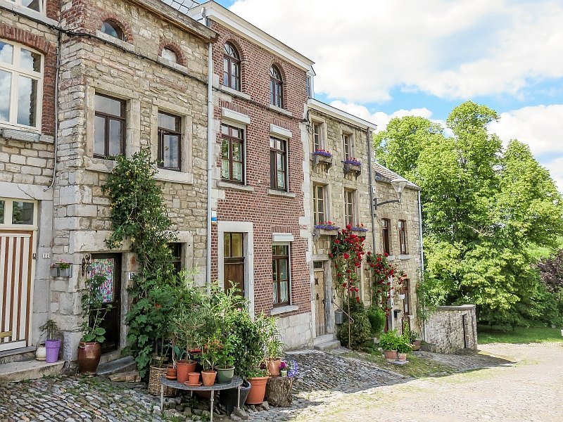 quaint stone houses with lots of lowers pots in front and a cobbled street, Limbourg Belgium