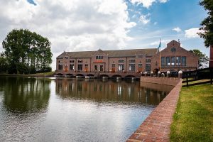 a large industrial type of a building with red bricks on the water, UNESCO Wouda pumping Station, Netherlands