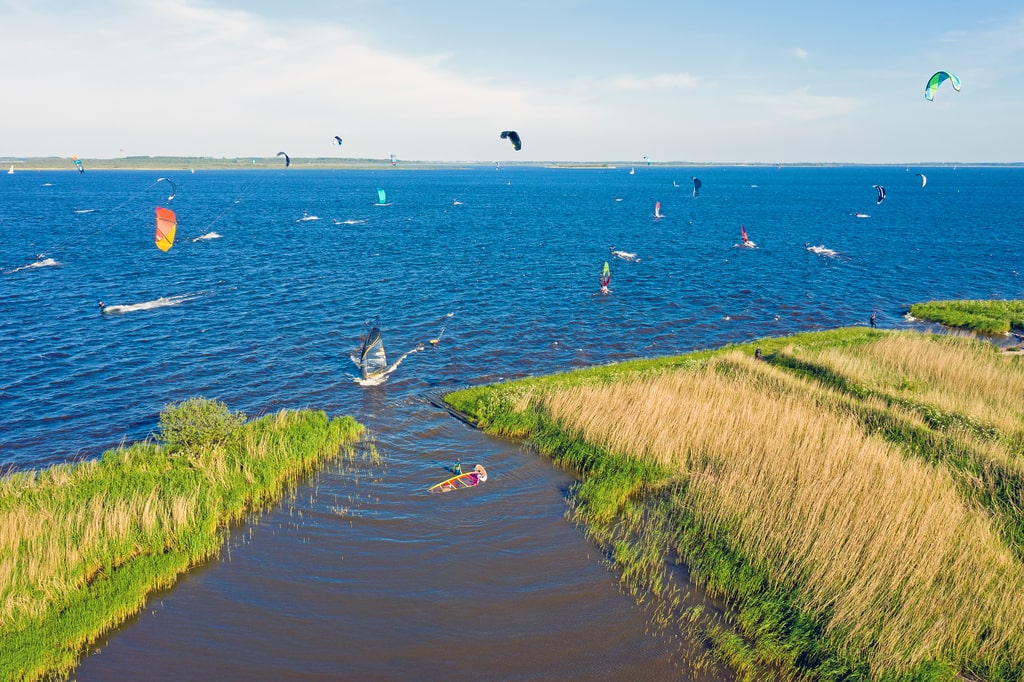 a lake with windsurfers and kitesurfers, Lauwersmeer National Park