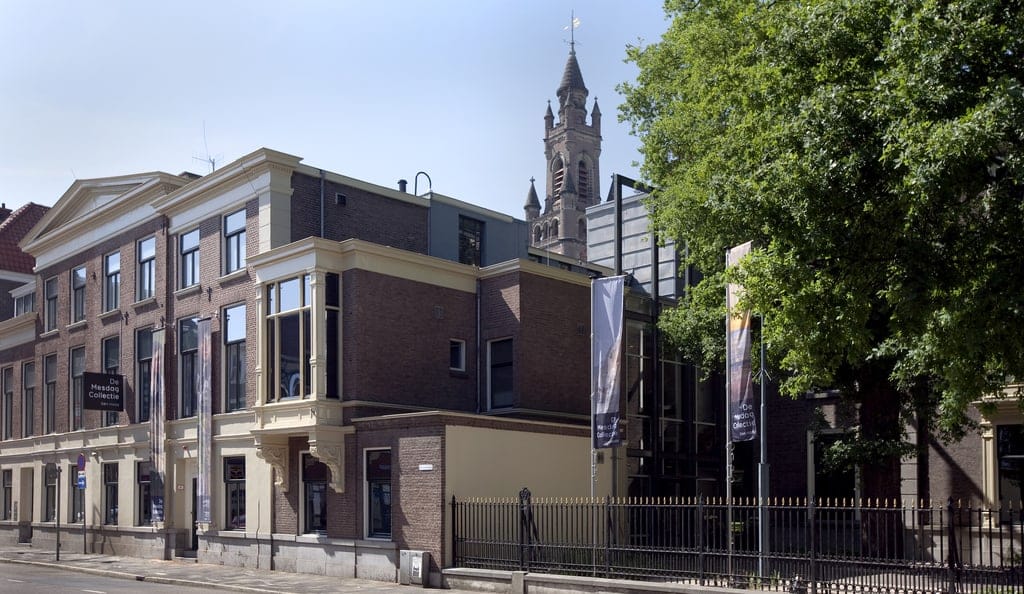 a building with two flags in front the a sign saying De Mesdag Collection