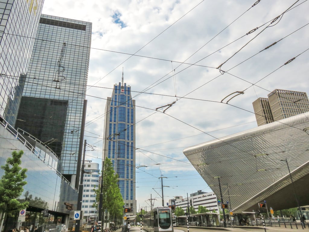 a street view of Rotterdam with modern buildings around the central railway station including Hotel Marriott