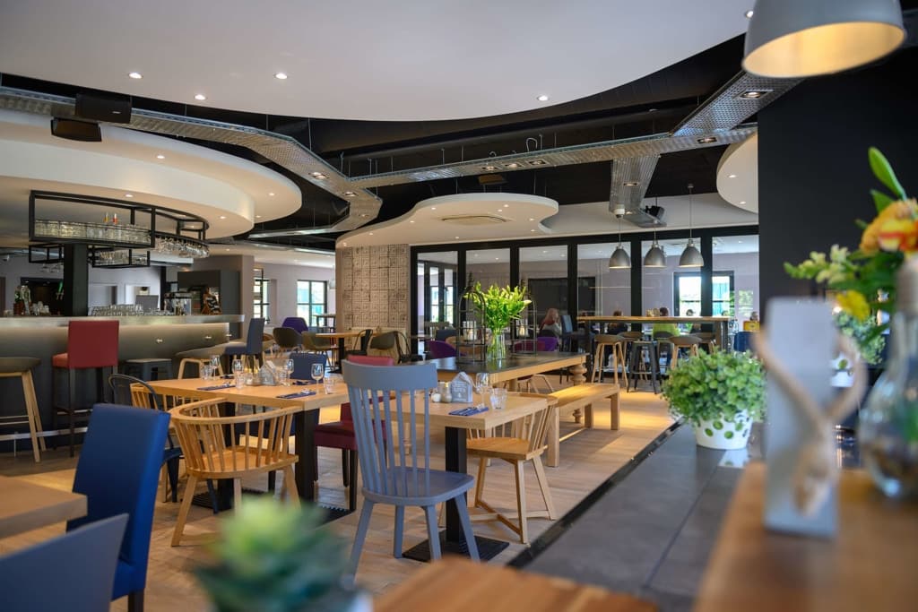 Campanile Hotel in Eindhoven: A restaurant with rustic wooden tables and chairs
