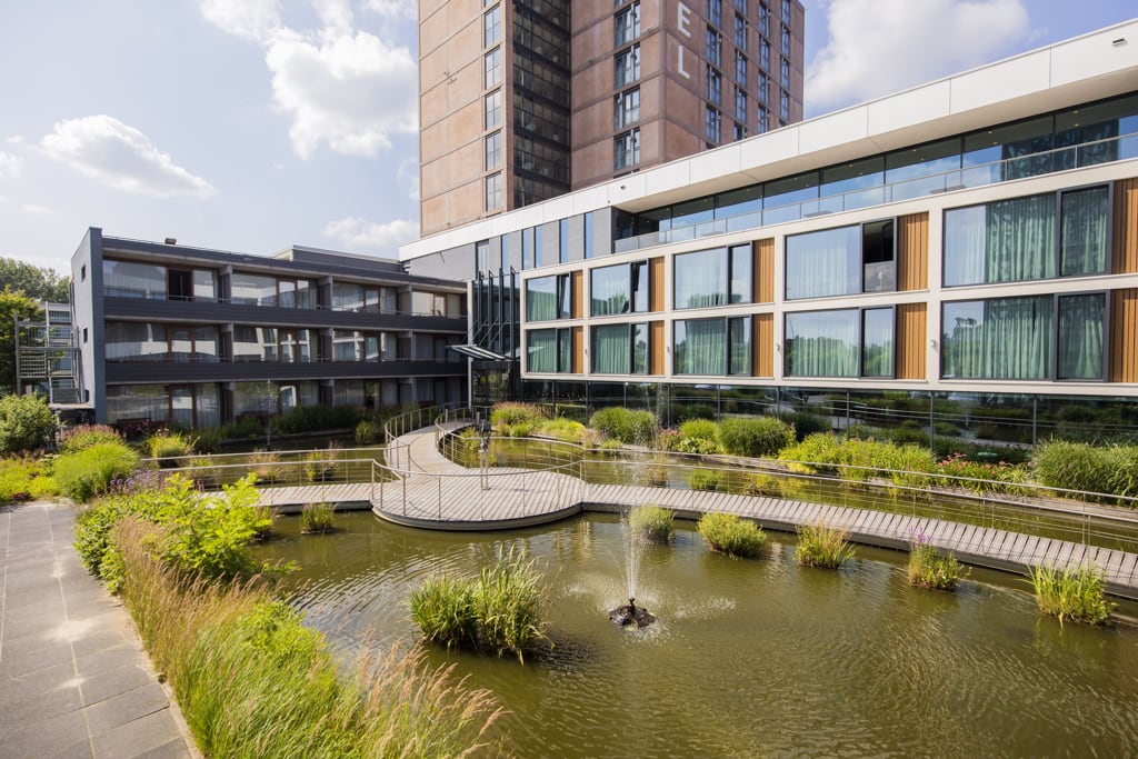 A contemporary building with a serene pond and a well-designed walkway, Van der Valk Hotel in Eindhoven